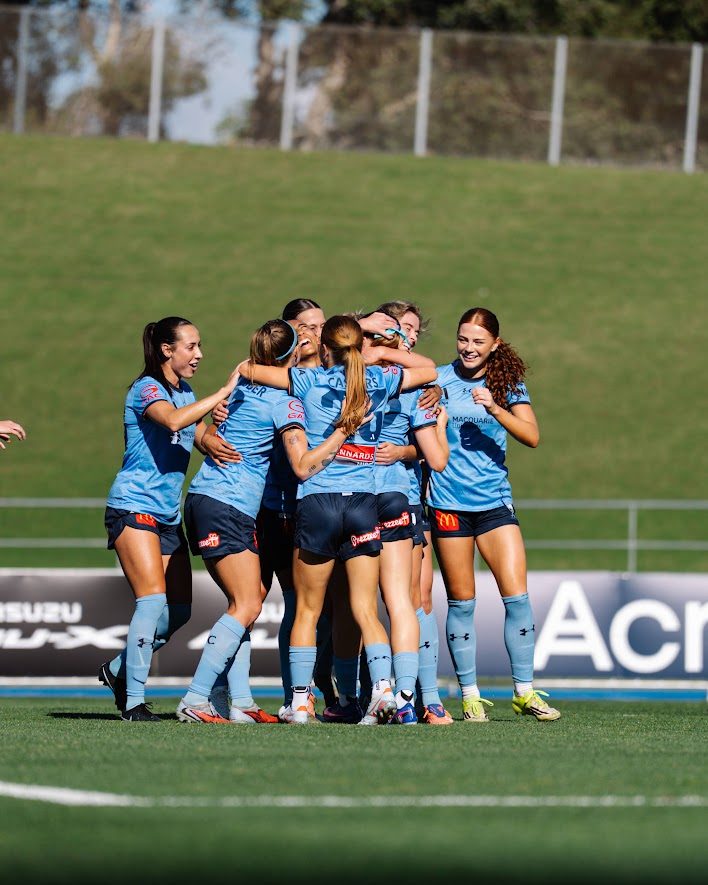 Sydney FC Women players hugging to celebrate a goal